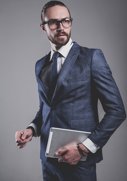 Free photo portrait of handsome fashion businessman model dressed in elegant blue suit with glasses