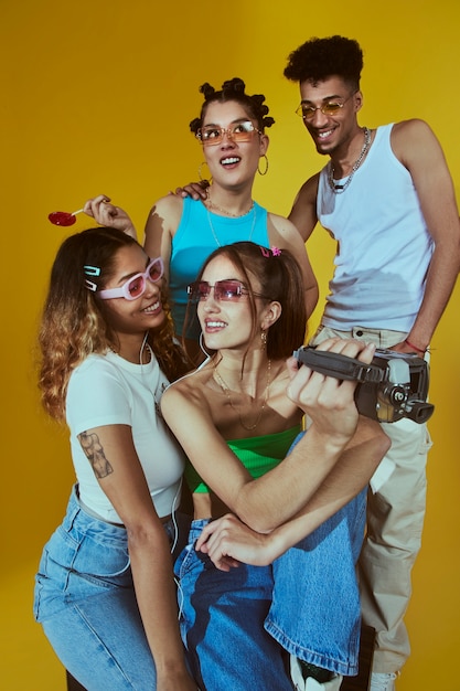 Бесплатное фото Портрет молодой группы друзей в стиле моды 2000-х, позирующих с камерой