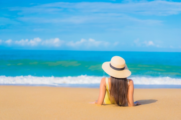 Бесплатное фото Портрет красивой молодой азиатской женщины ослабляя на пляже в каникулах перемещения