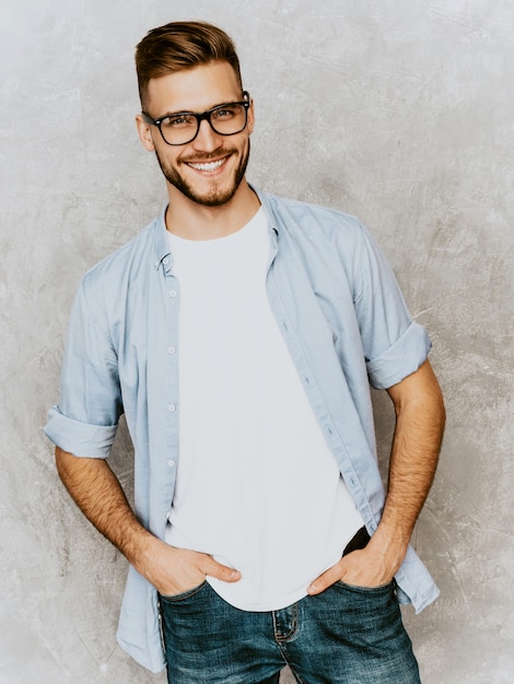 Бесплатное фото Портрет красивый улыбающийся молодой человек модель носить повседневную рубашку одежду. модный стильный мужчина позирует в очках
