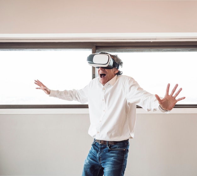 Free photo portrait of senior excited man experiencing virtual reality