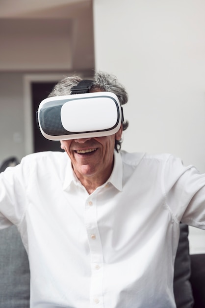 Free photo portrait of smiling senior man wearing virtual reality goggles