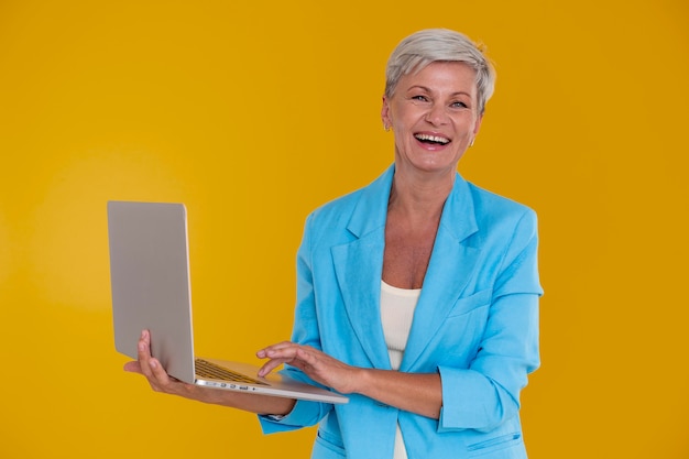 Портрет стильной старшей женщины, держащей ноутбук