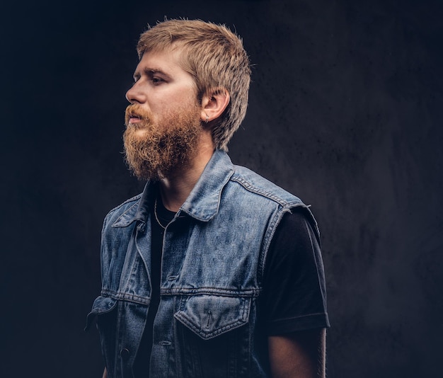 Free photo profile of a hipster guy dressed in jeans jacket. isolated on a dark background.