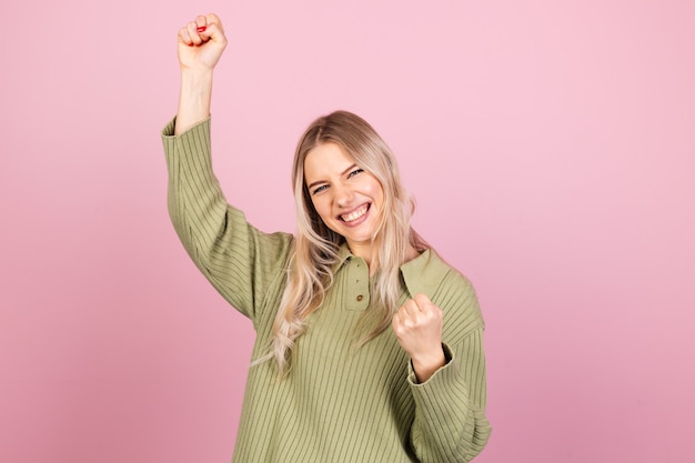 Бесплатное фото Довольно европейская женщина в повседневном вязаном свитере на розовой стене
