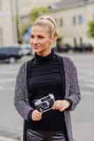 Бесплатное фото Красивая женщина с камерой на улице