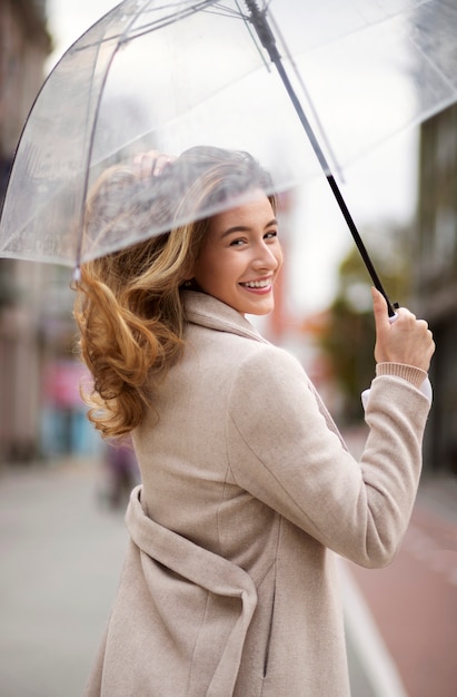 Бесплатное фото Дождь портрет молодой красивой женщины с зонтиком