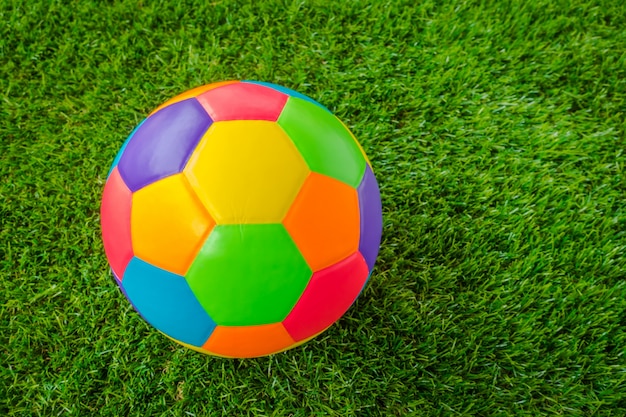 Бесплатное фото Натуральная кожа красочные многоцветной футбольный мяч на зеленой траве.
