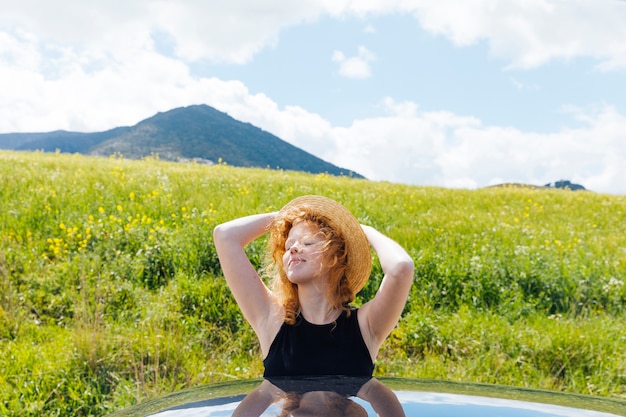 Free photo red-haired woman enjoying sunshine
