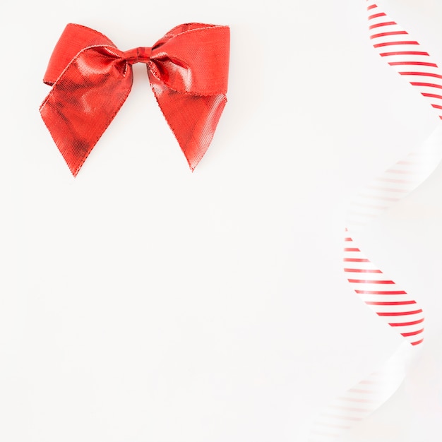 Red stain bow and striped ribbon on white background