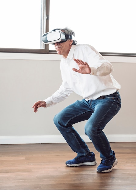 Free photo senior man standing in the room experiencing virtual reality