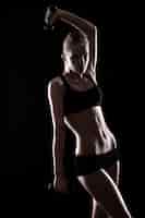 Бесплатное фото Сексуальная девушка делает упражнения с гантелями