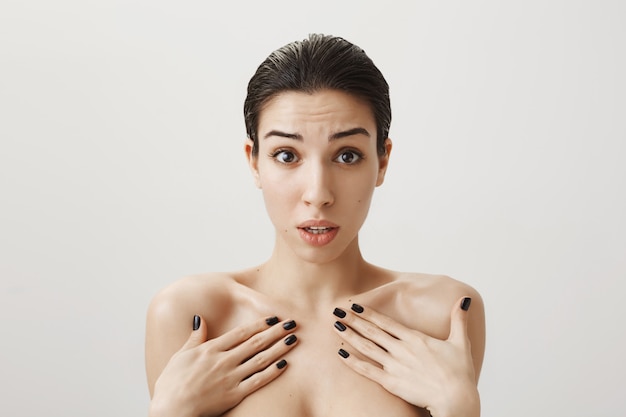 Free photo shocked and confused woman standing naked, pointing herself accused in something