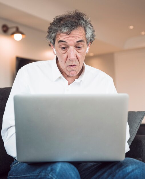 Shocked senior man looking at laptop