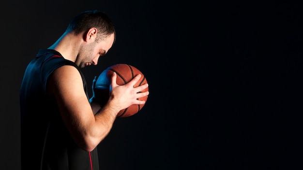 Вид сбоку баскетболиста с копией пространства
