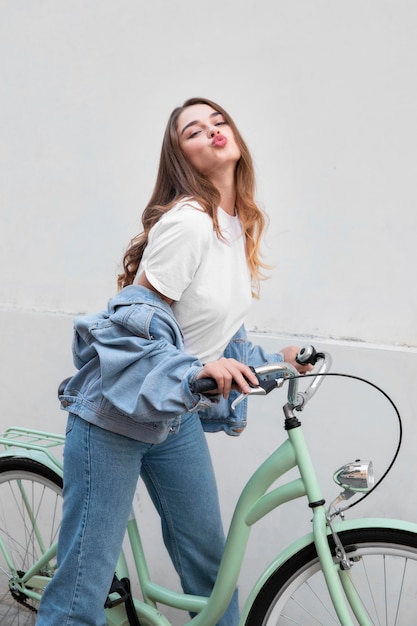무료 사진 그녀의 자전거에 앉아있는 동안 그녀의 입술을 삐죽 여자의 측면보기