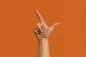 Free photo sign language symbol isolated on orange