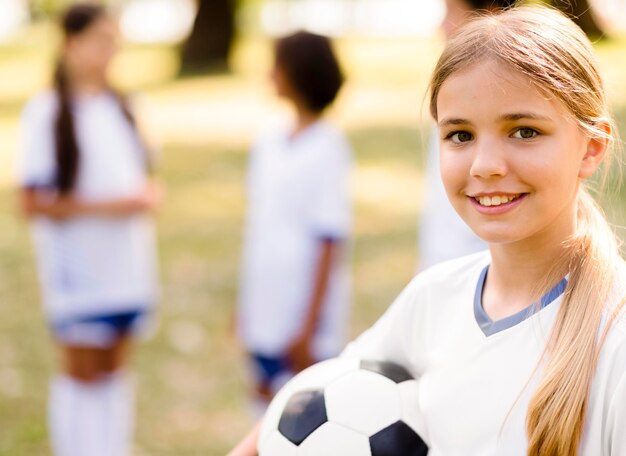Смайлик девушка держит футбол
