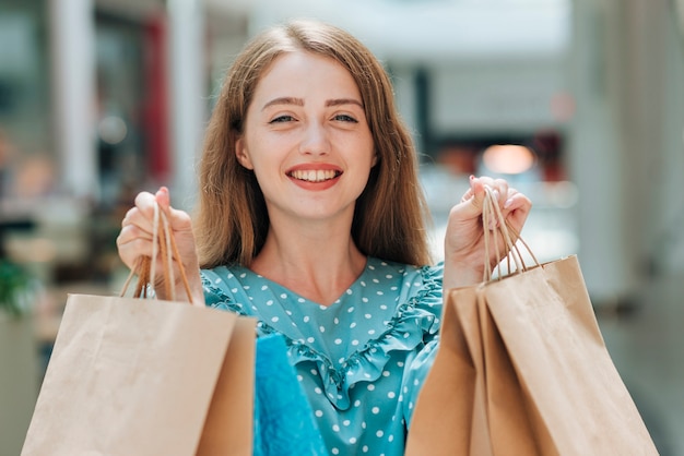 Free photo smiley girl holding shopping bags