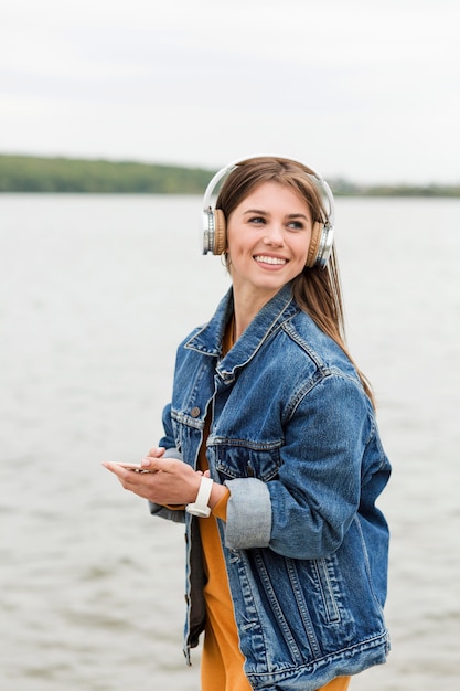 Бесплатное фото Смайлик женщина слушает музыку на берегу моря