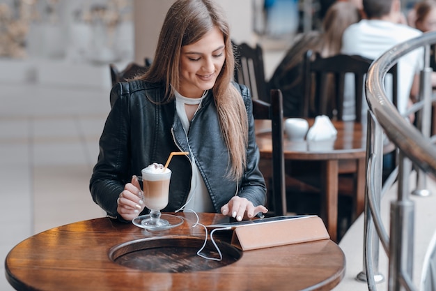 Бесплатное фото Улыбается девушка с планшета и льстец на столе