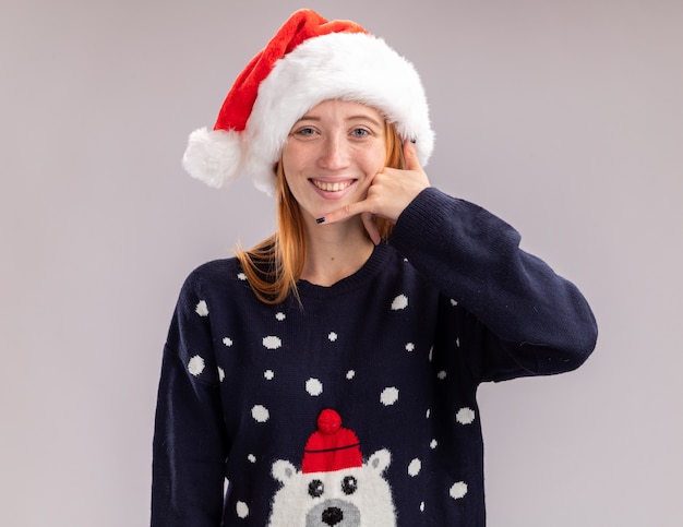 Free photo smiling young beautiful girl wearing christmas hat showing phone call gesture isolated on white wall