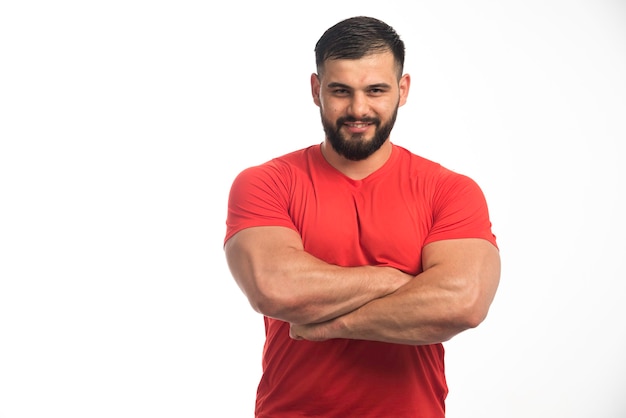 Бесплатное фото Спортивный мужчина в красном, показывая свои мышцы.
