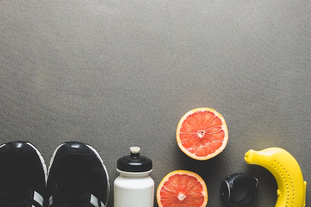 Бесплатное фото Спортивное оборудование рядом с грейпфрутом