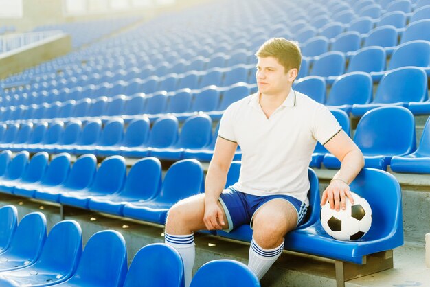 Спортсмен и футбольный мяч на стадионе