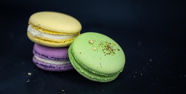 Free photo sweet and colorful french macaroons or macaron on black background