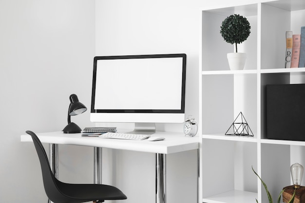 Photo gratuite bureau avec écran d'ordinateur et chaise de bureau