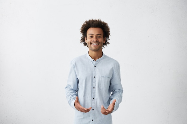 Photo gratuite beau jeune homme afro-américain portant une chemise longue légère souriant