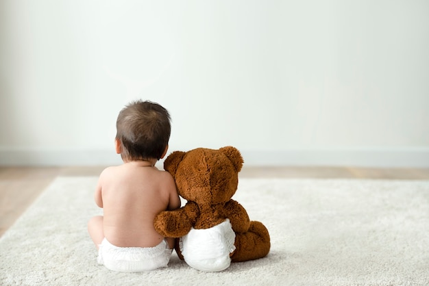 Photo gratuite bébé et ours en peluche vue arrière avec espace design