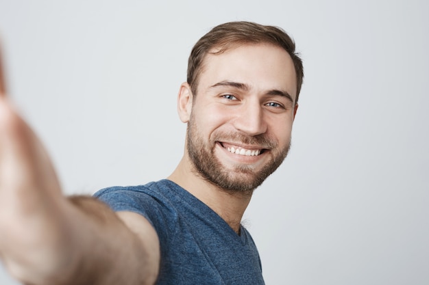 Photo gratuite bel homme souriant prenant selfie