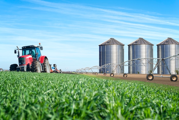 Photo gratuite concept de production agricole et alimentaire avec silos de machines de tracteur et système d'irrigation