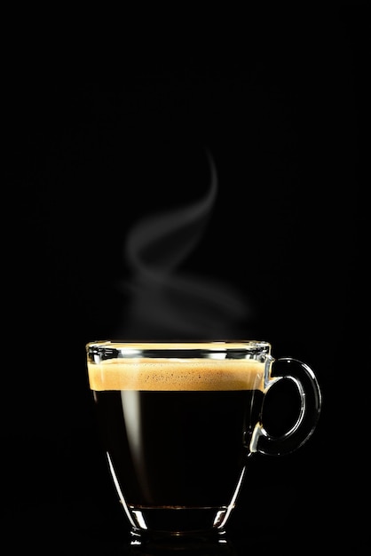 Photo gratuite espresso sur fond sombre, la vapeur s'élève au-dessus du café. café pour le petit déjeuner dans un café italien, tir vertical, mise au point sélective