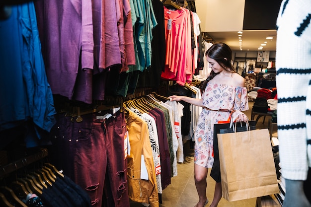 Photo gratuite femme choisissant des vêtements dans la boutique