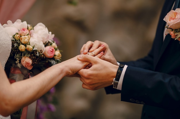 Photo gratuite groom mettant bague au doigt de la mariée