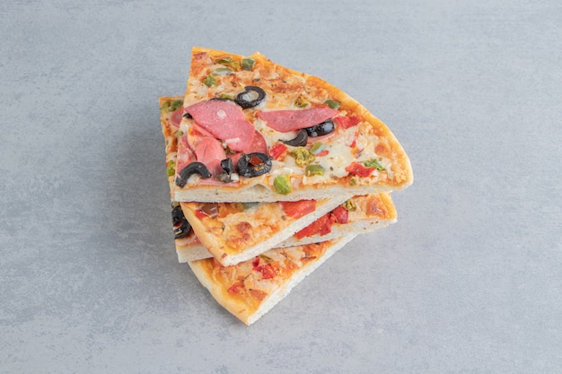 Photo gratuite une petite pile de tranches de pizza sur marbre