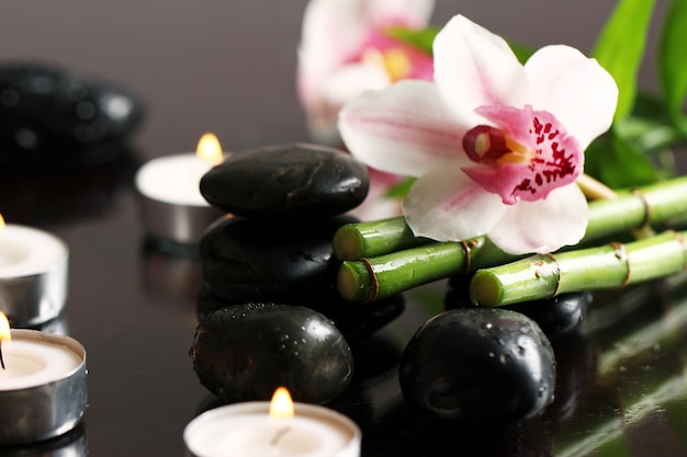 Photo gratuite spa et bien-être, pierres de massage et fleurs sur nappe en bois