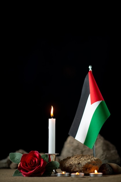 Photo gratuite vue de face du drapeau palestinien avec des bougies allumées dans l'obscurité