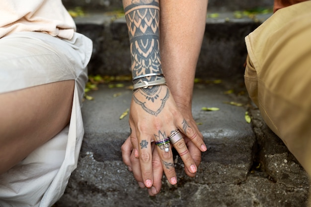 Photo gratuite vue de face des tatoués se tenant la main
