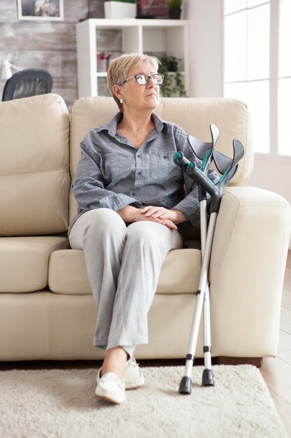 Vieille femme solitaire à la retraite assise sur un canapé dans une maison de retraite.