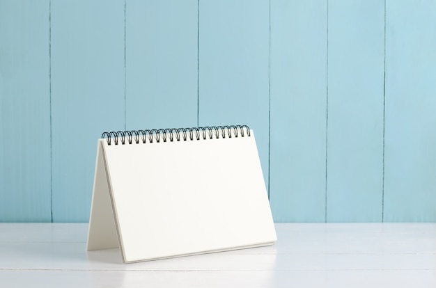 Photo calendrier de bureau blanc sur fond en bois blanc et bleu