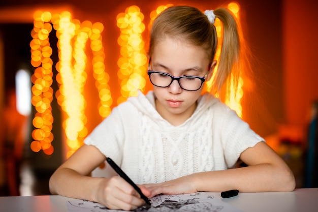 Photo adorable petite fille écrit une lettre au père noël assis sur la table