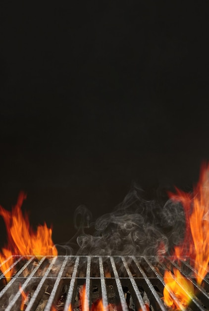 Photo barbecue barbecue vide chaud avec feu flamboyant lumineux, charbon de braise et fumée sur fond noir. en attente du placement de votre nourriture. concept de cuisine. gros plan, copiez l'espace