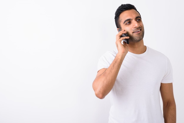 Beau jeune homme indien à l'aide de téléphone portable contre backg blanc