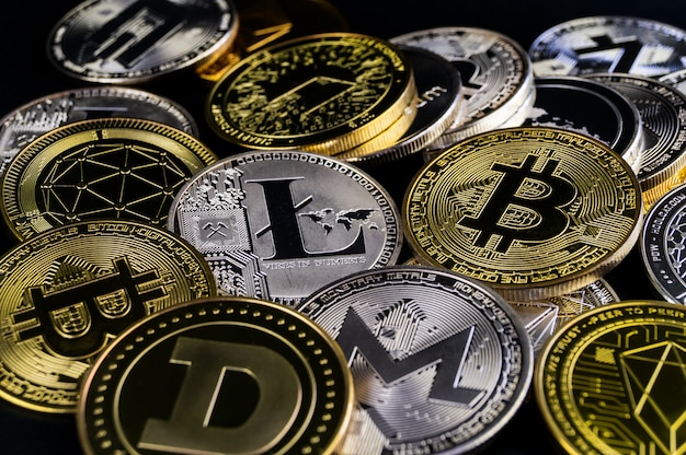 Un grand nombre de pièces de crypto-monnaie se trouvent sur une surface sombre
