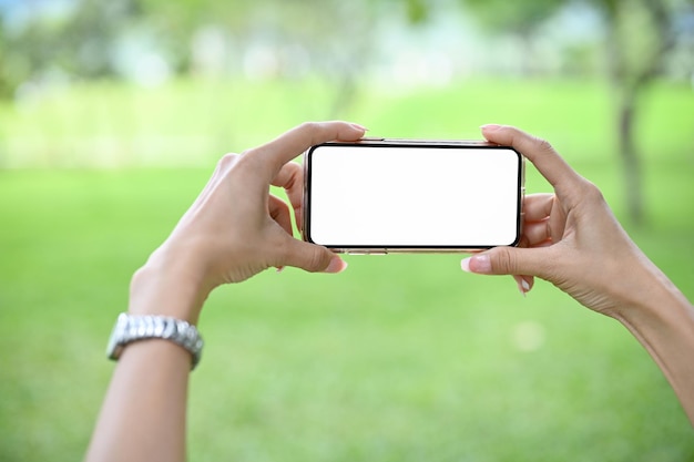 Gros plan Les mains d'une femme utilisant un smartphone pour prendre une photo de la belle vue