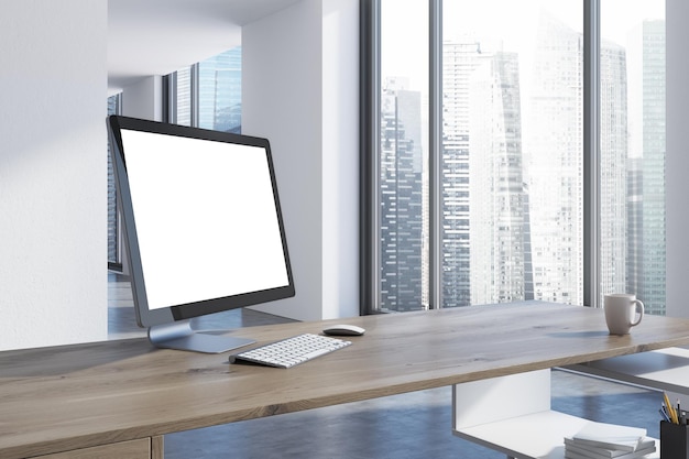 Photo Écran d'ordinateur blanc sur le côté d'un bureau en bois
